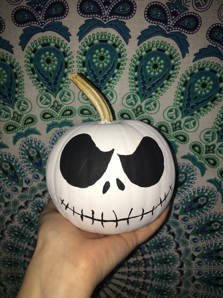 a hand holding a jack skellingy pumpkin