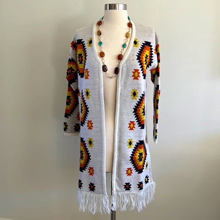 a woman's white cardigan sweater with multicolored beads and tassels