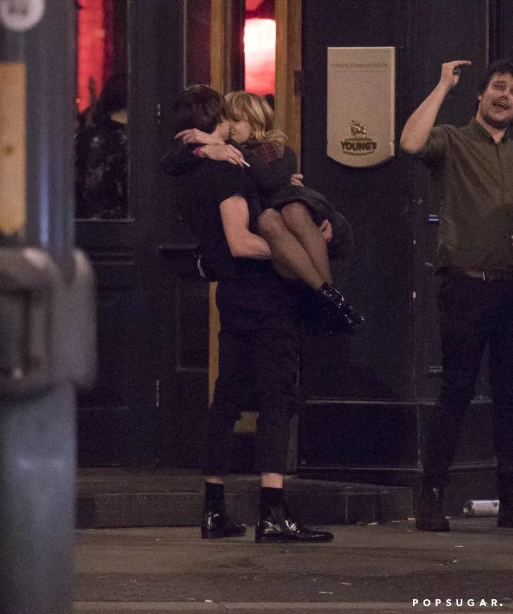 two people hugging each other on the street