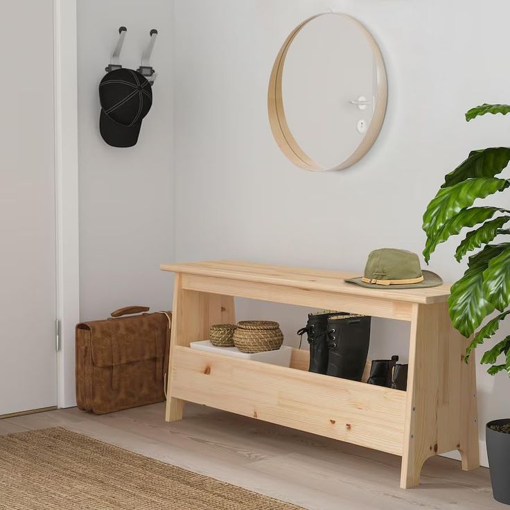 a wooden bench sitting next to a potted plant on top of a hard wood floor