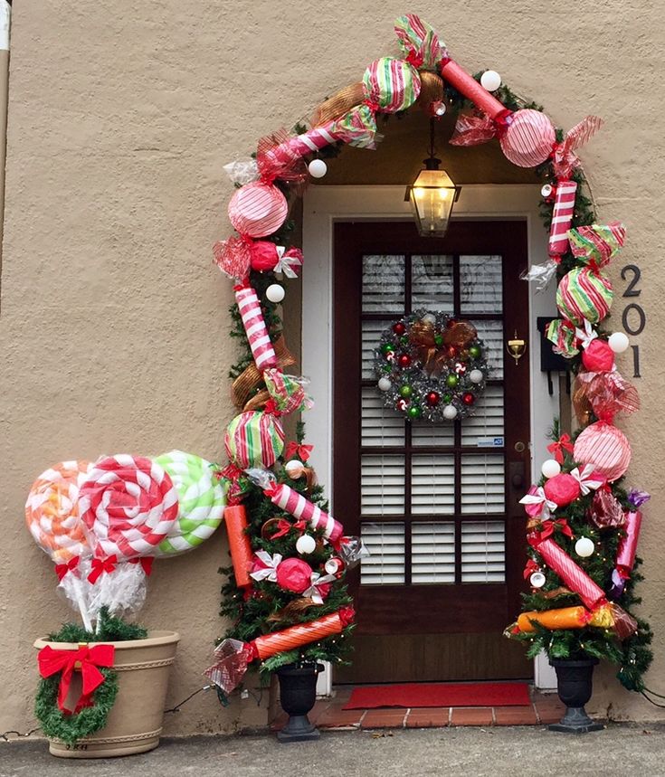 the front door is decorated with candy canes and wreaths