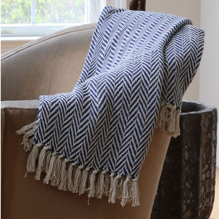 a blue and white blanket sitting on top of a chair