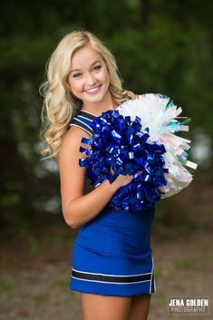 a beautiful young woman holding a cheerleader's pom - pom in her hands