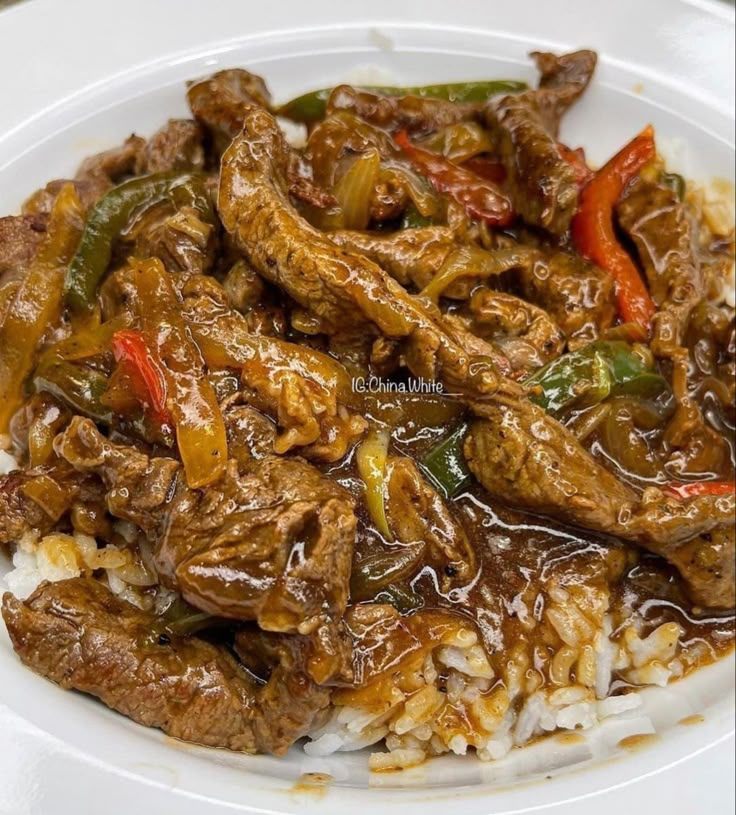 a white plate topped with meat and rice