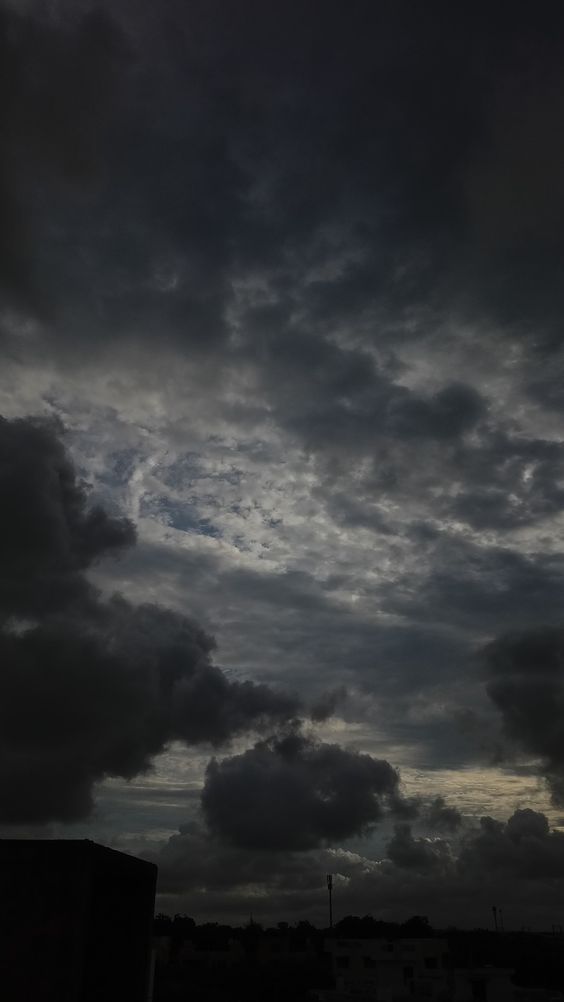 the sky is very dark and cloudy with some clouds in it's foreground