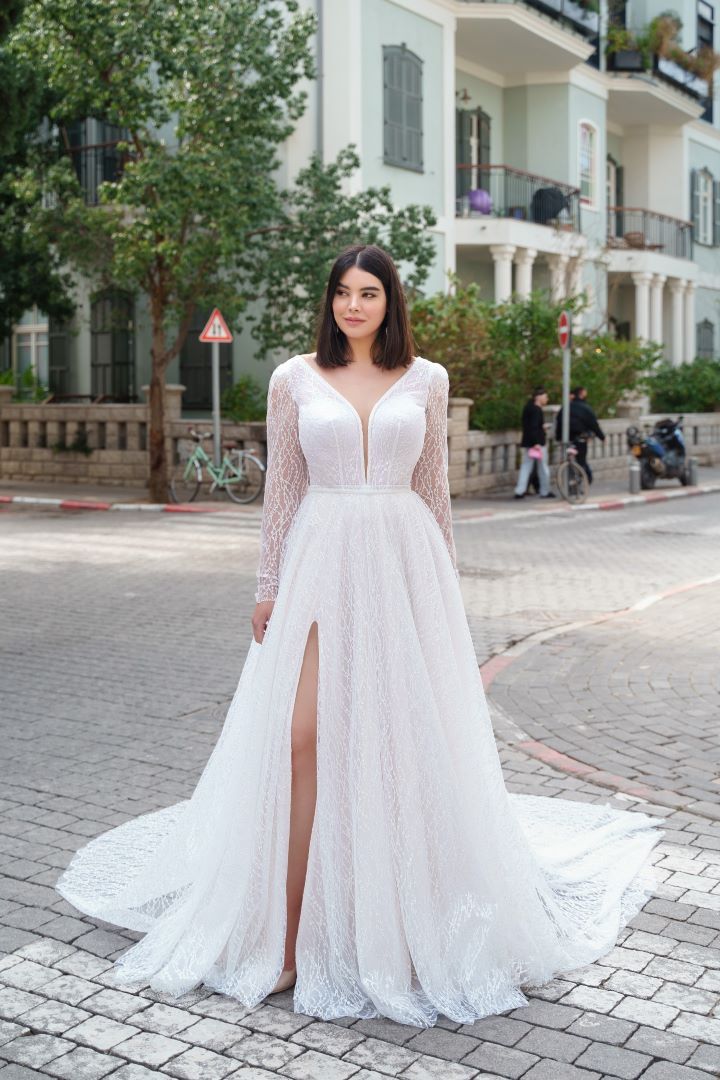 a woman in a white wedding dress standing on the street