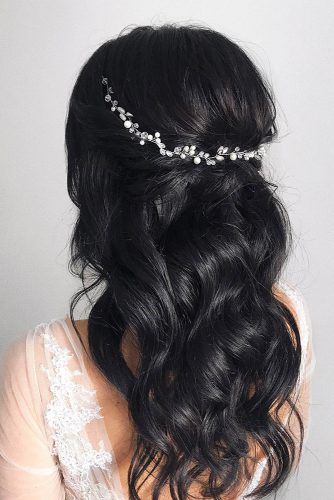 the back of a woman's head wearing a bridal hair piece with pearls on it