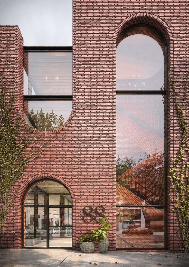 a brick building with two arched windows on the front and side, along with an entry way leading to another building