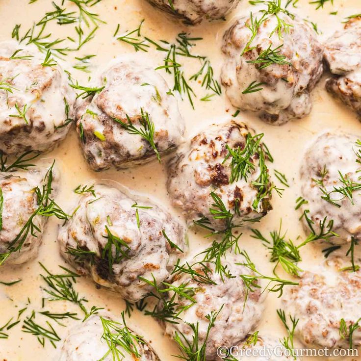 meatballs covered in gravy and garnished with fresh herbs