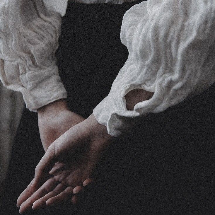 a woman wearing a white shirt and black skirt holding her hands out to the side