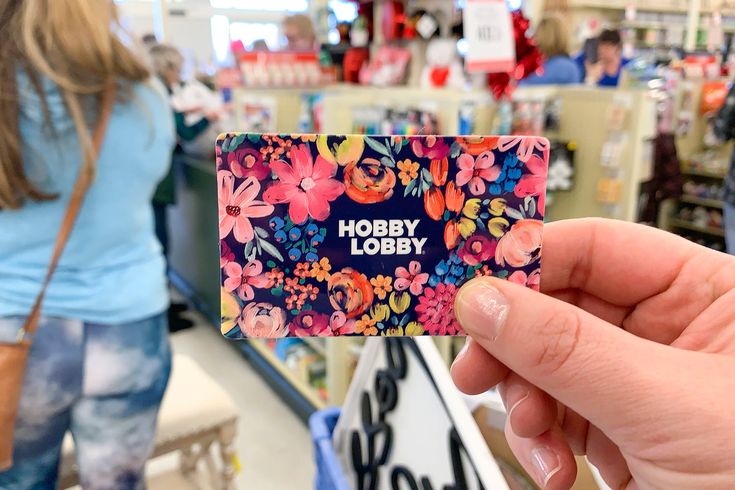 a person holding up a business card with the words hobby lobby in front of them