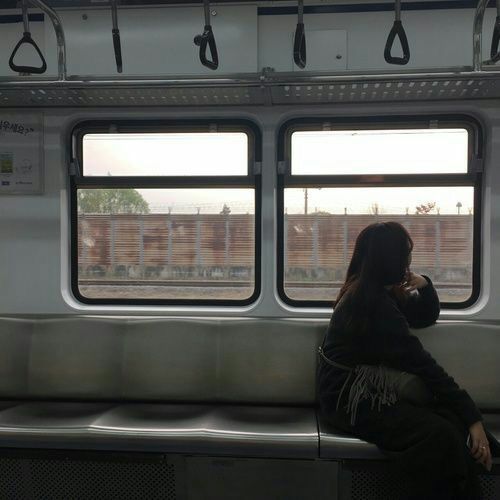 a woman sitting on a train looking out the window