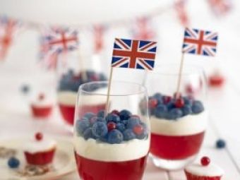 red, white and blue desserts in glasses with flags on sticks sticking out of them