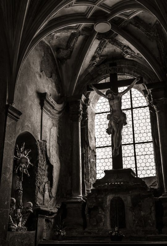 an old church with a crucifix and stained glass window