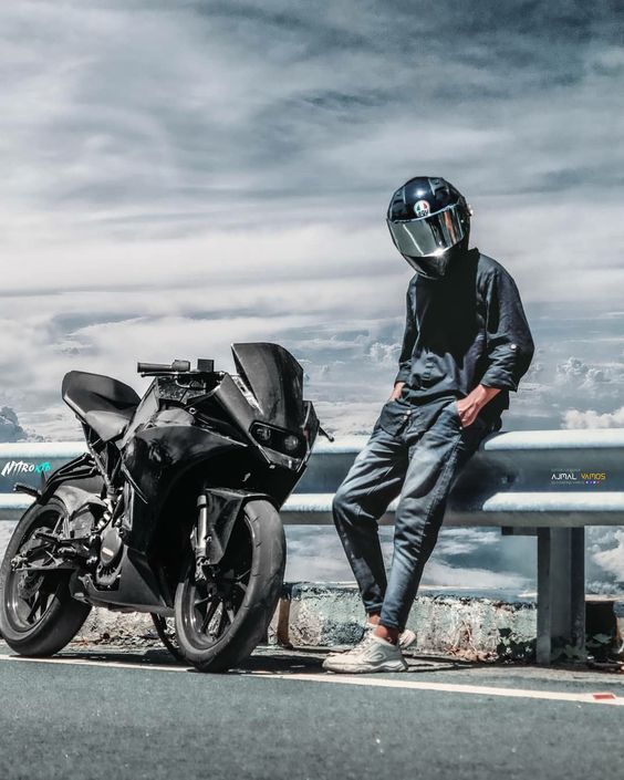 a man sitting on a bench next to a parked motorbike and wearing a helmet