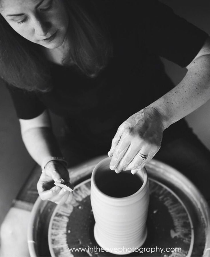 black and white photograph of a woman making something out of a pot on a wheel