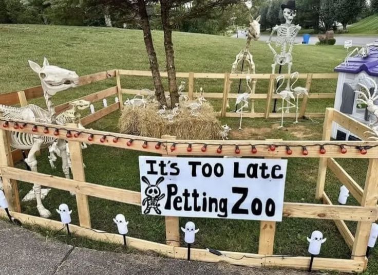 there is a fence with skeletons in it and a sign that says it's too late getting zoo