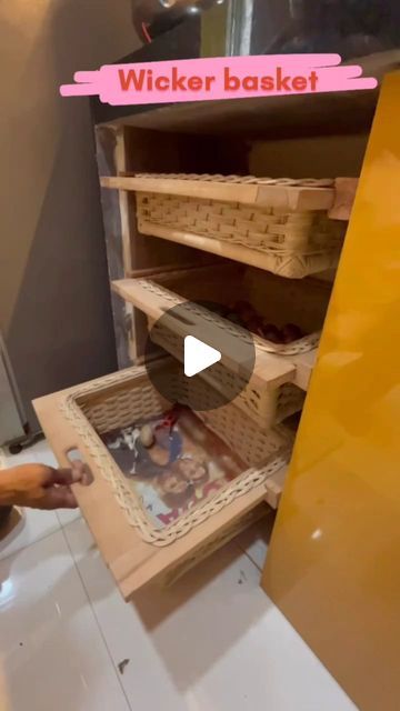 a person is placing baskets in a basket on top of a shelf that's open