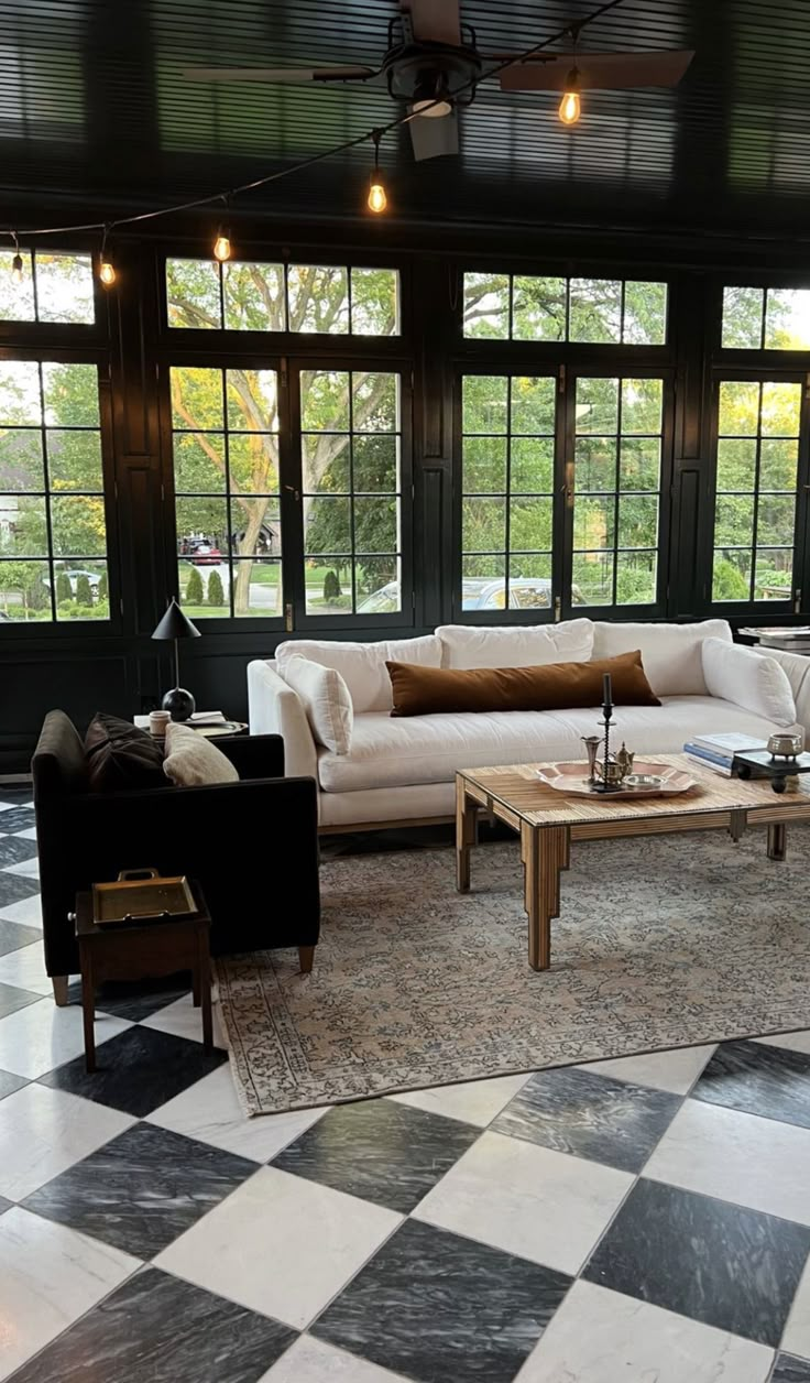 a living room with black and white checkered flooring, two couches and coffee table