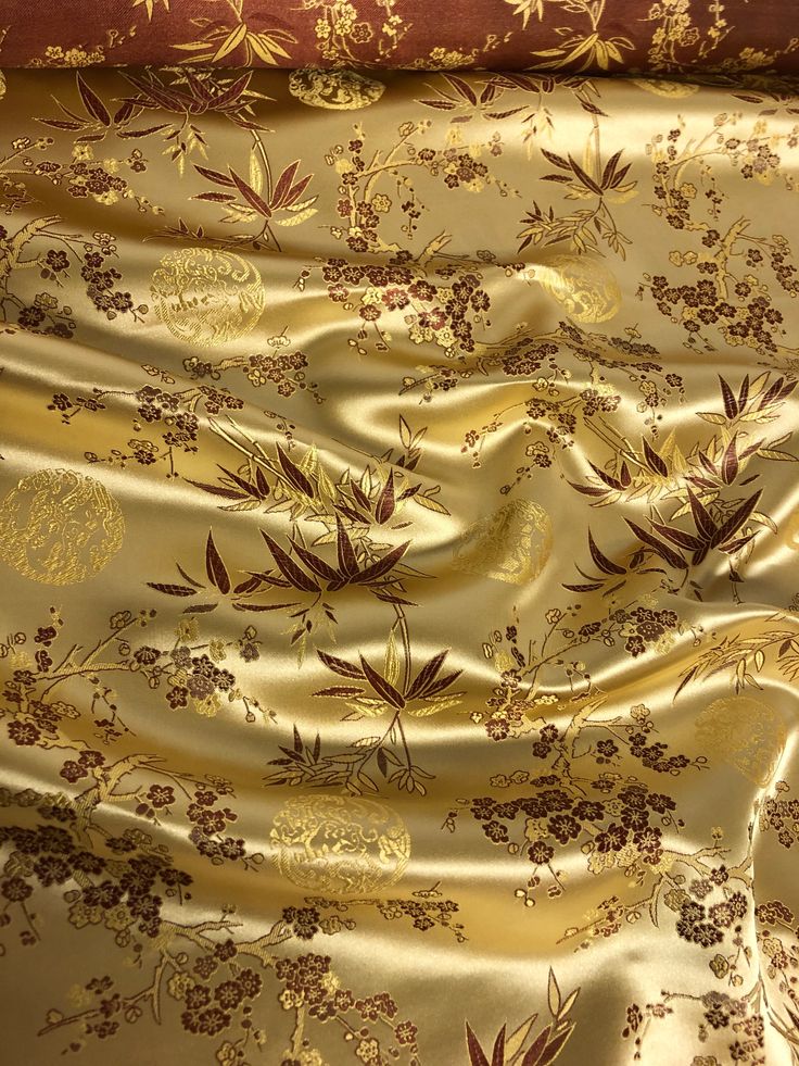 the fabric is gold and brown with flowers on it