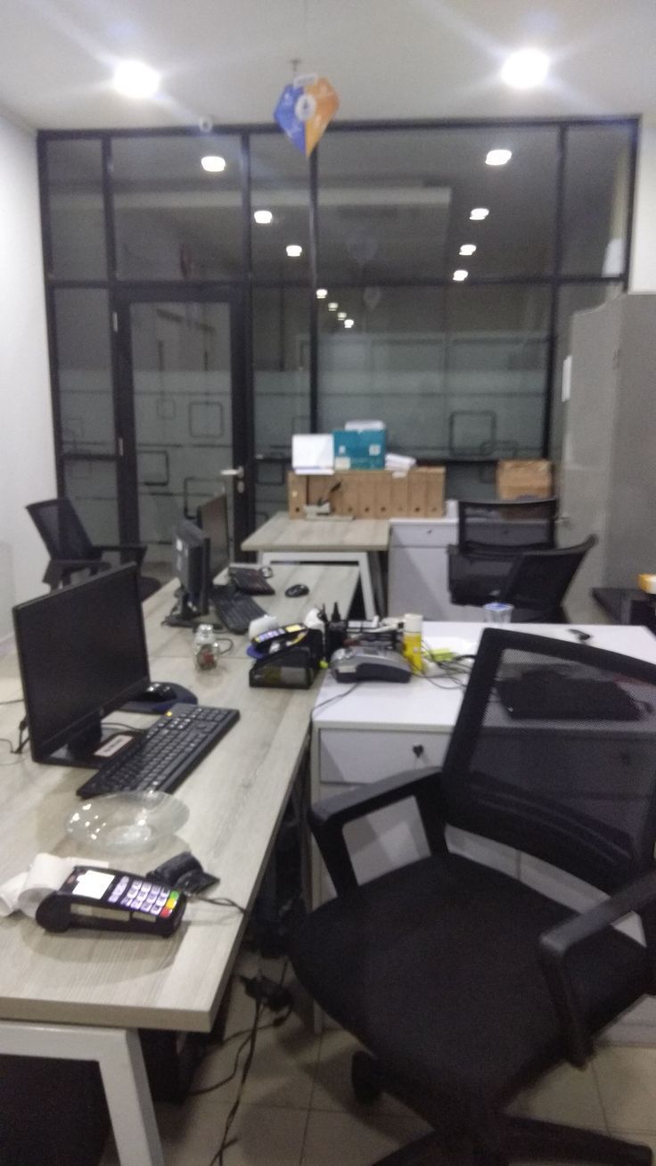 an office desk with two computers on top of it and several other electronic devices sitting on the desk