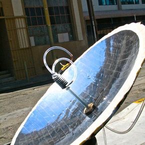 a large satellite dish sitting on top of a metal stand in front of a building