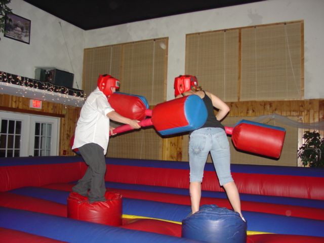 two people standing on top of red and blue inflatables with boxing gloves