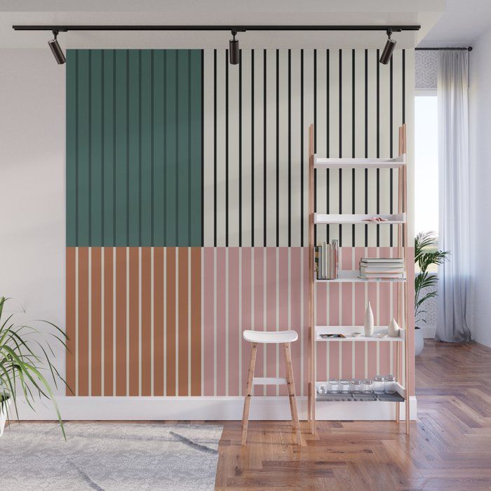 a living room with a chair, table and bookshelf in front of a striped wall