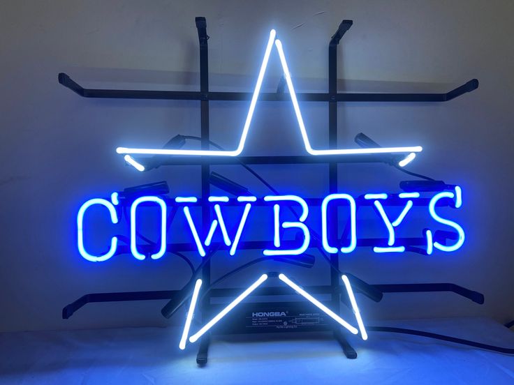 a neon sign that says cowboys in the shape of a star on a white background