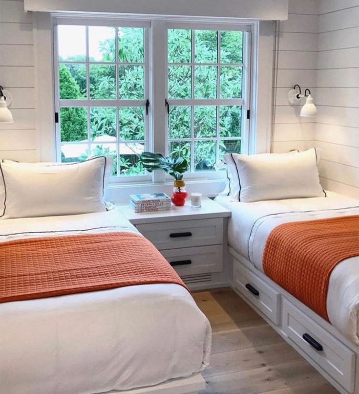 two beds in a room with white walls and wood floors