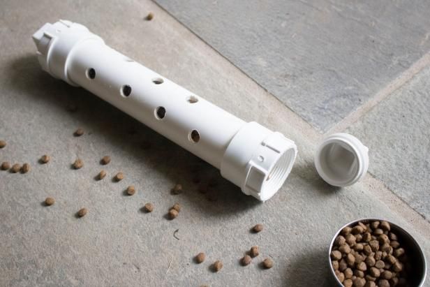 a white flute is next to a bowl of dog food on the floor with it's lid open