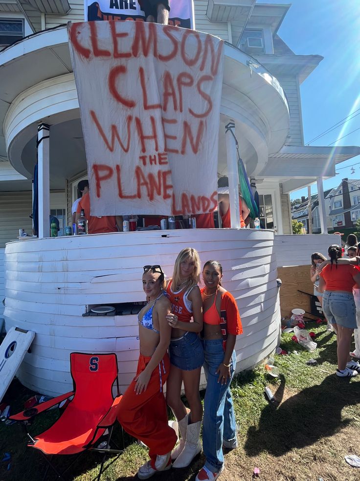 three girls standing in front of a boat with the words clemson claps when the plane lands