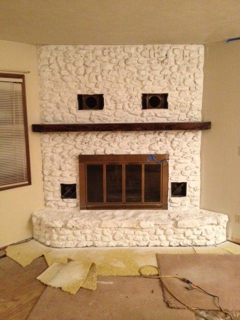 a living room with a fire place in the middle of it's flooring