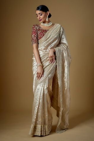 Champagne gold tulle and handloom tissue silk saree with pearls, cutdana and glass beaded hand embroidery. Comes with a chillie red padded blouse and an underskirt. - Aza Fashions Tussar Silk Blouse Piece With Sheer Dupatta For Reception, Wedding Blouse With Sheer Dupatta In Dola Silk, Raw Silk Saree With Gota Work For Reception, Reception Raw Silk Saree With Gota Work, Elegant Pre-draped Saree In Tissue Silk With Gota Work, Elegant Pre-draped Tissue Silk Saree With Gota Work, Elegant Tissue Silk Pre-draped Saree With Gota Work, Elegant Raw Silk Blouse Piece With Gota Work, Elegant Blouse Piece With Gota Work For Reception