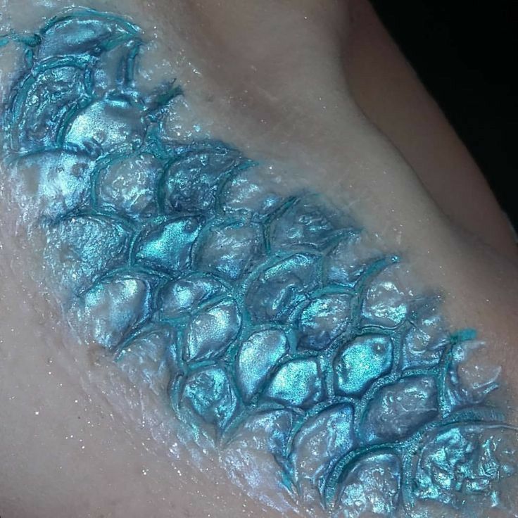 a close up of a person's skin with blue paint on it