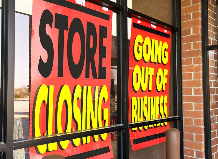 a store front window with signs on the glass saying closing and going out of business