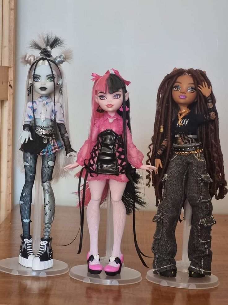 three dolls standing on top of wooden floor next to each other