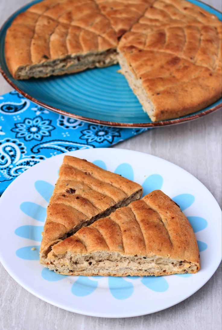 there is a piece of bread on the plate next to another pie that has been cut in half