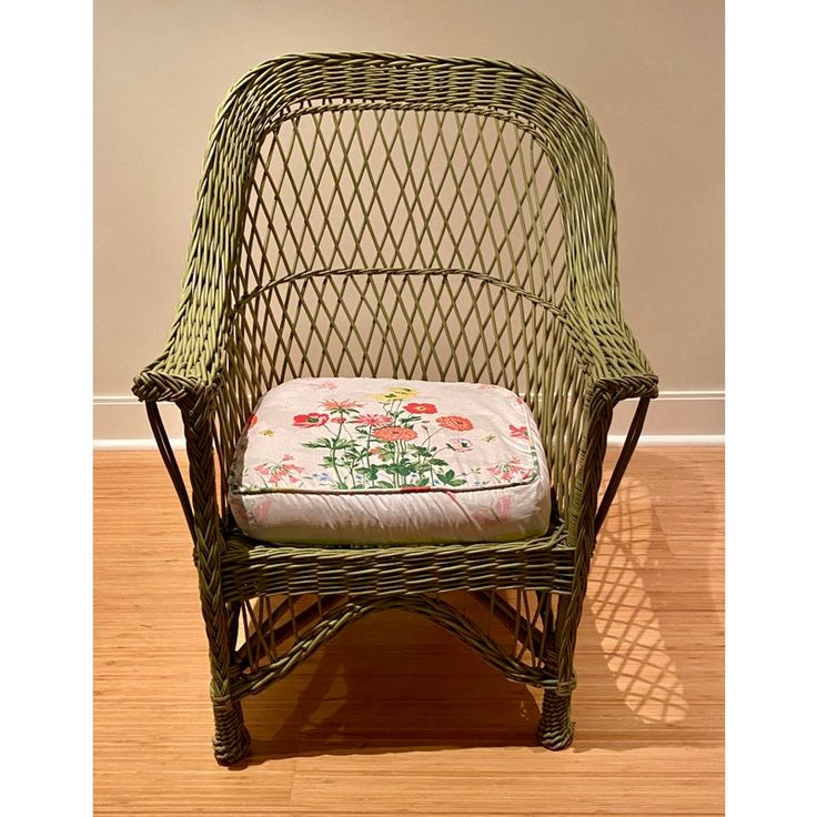 a wicker chair with a flowered cushion on the seat and wooden flooring