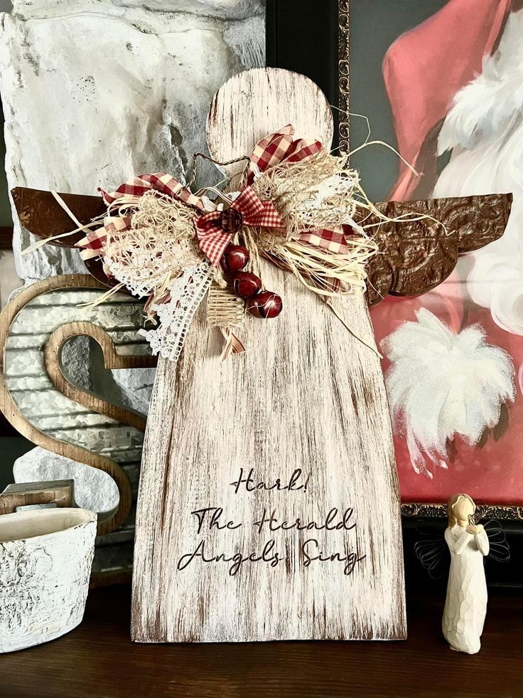 a white angel statue sitting on top of a wooden table next to a framed photo