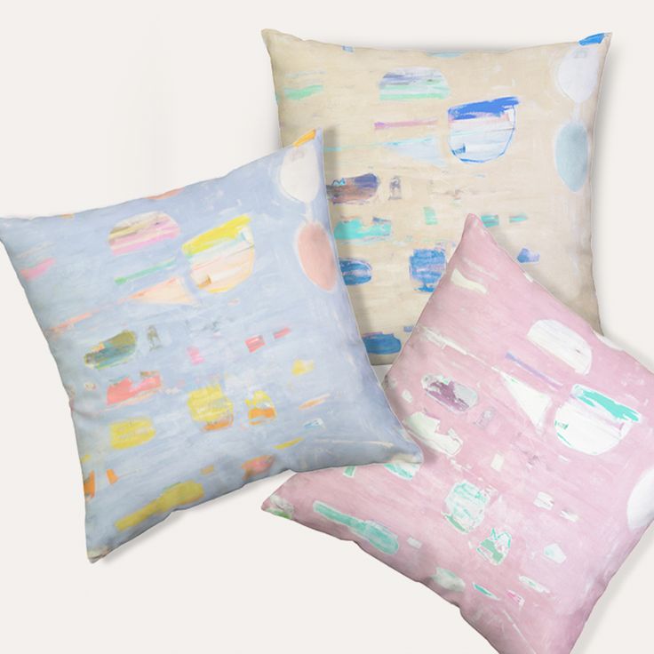 three pillows with different designs on them, one in pink and the other in blue