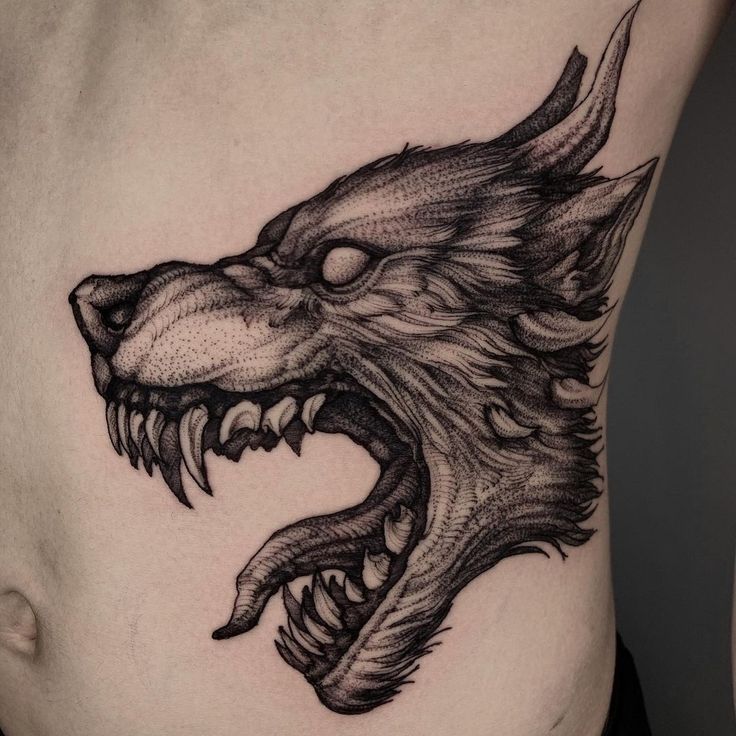 a close up of a tattoo on the side of a woman's stomach with a dragon head