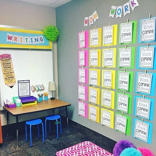 an office decorated in bright colors with posters on the wall and colorful pom poms