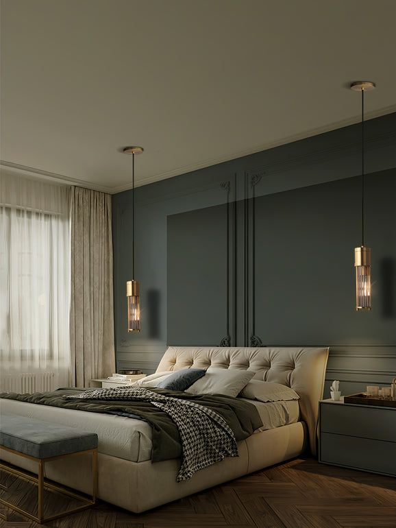 a bedroom with a large bed and two lamps hanging from the ceiling over it's headboard