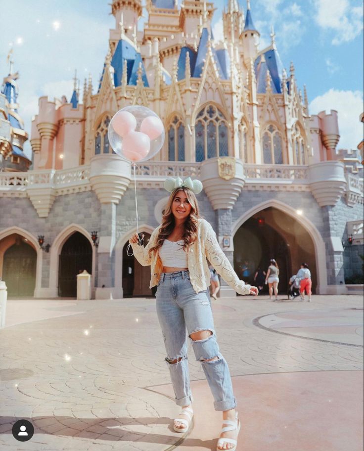 a woman standing in front of a castle with balloons