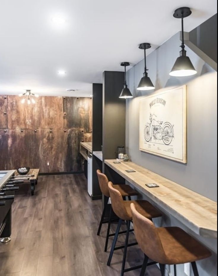 a room that has some tables and stools in it with lights hanging from the ceiling