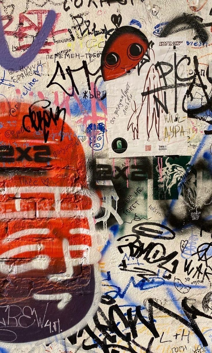 a wall covered in lots of graffiti and writing