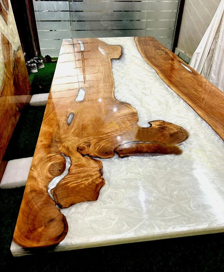 a table made out of wood with white and brown designs on it's surface