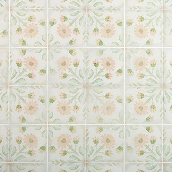 a white tiled wall with pink and green flowers painted on the tiles in different colors