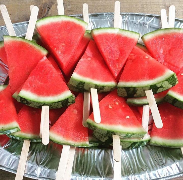 slices of watermelon are arranged on skewers